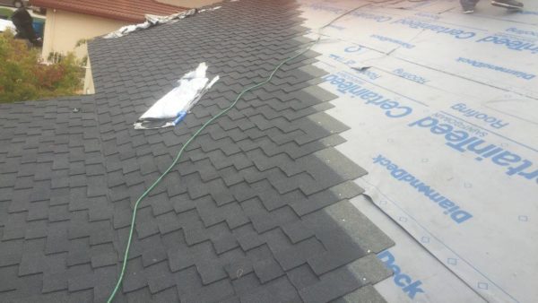 asphalt shingles being added to a residential roof during a reroofing 